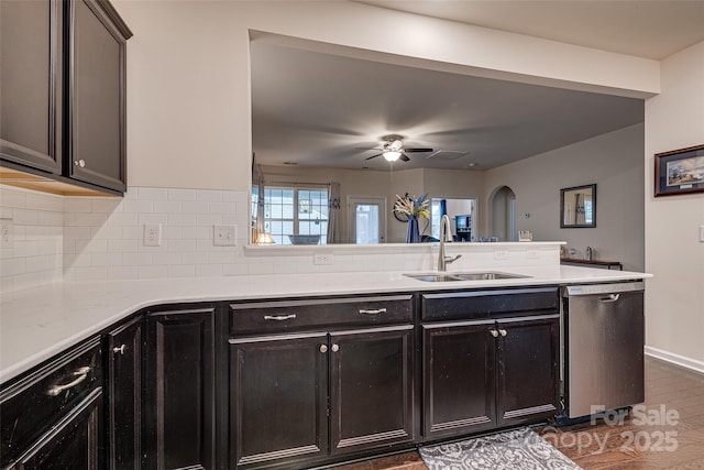 kitchen featuring ceiling fan, sink, tasteful backsplash, stainless steel dishwasher, and kitchen peninsula