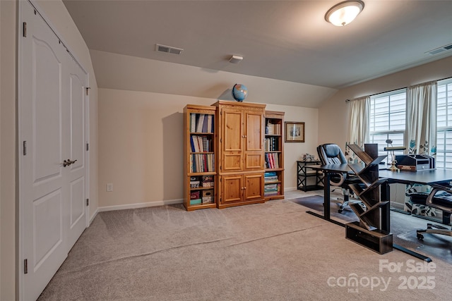 home office with light carpet and vaulted ceiling