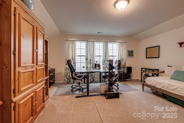 bedroom with light colored carpet and lofted ceiling