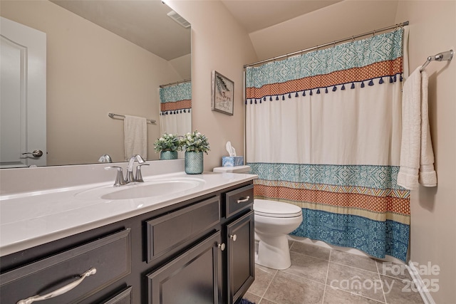 bathroom with tile patterned flooring, vanity, and toilet