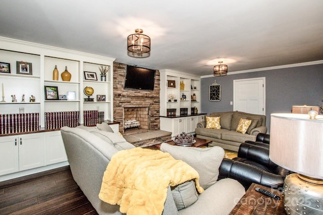 living room with crown molding, built in shelves, a fireplace, dark hardwood / wood-style flooring, and a chandelier