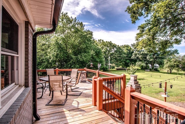 wooden terrace featuring a lawn