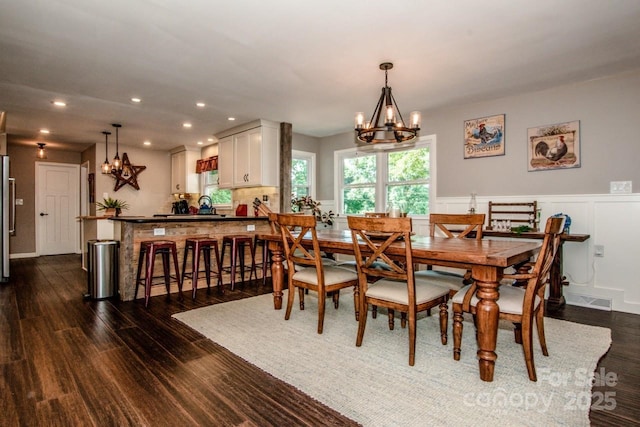 dining area featuring a notable chandelier and dark hardwood / wood-style flooring