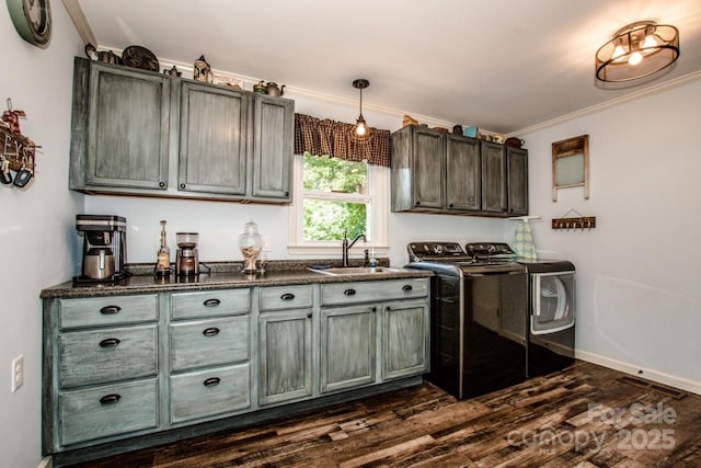 kitchen with pendant lighting, sink, washer and dryer, ornamental molding, and dark hardwood / wood-style flooring