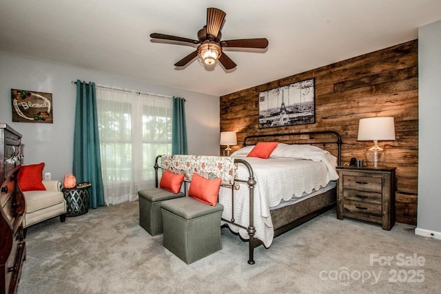 carpeted bedroom with ceiling fan and wooden walls