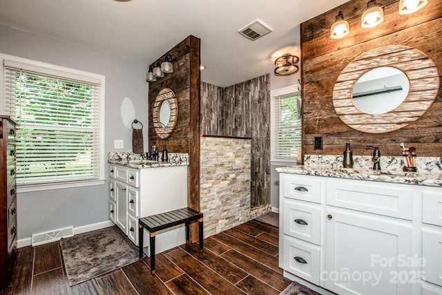 bathroom with walk in shower, vanity, and plenty of natural light