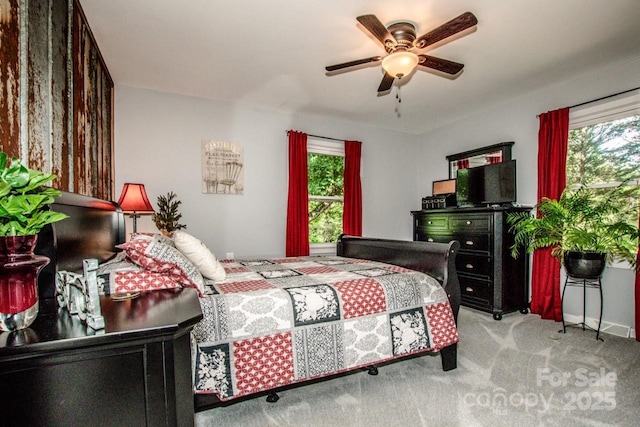 bedroom featuring ceiling fan, light carpet, and multiple windows