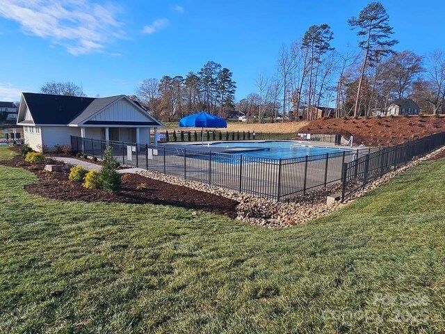 view of pool with a lawn