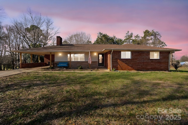 ranch-style home featuring a yard and a carport