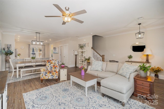 living room with hardwood / wood-style flooring, crown molding, and ceiling fan