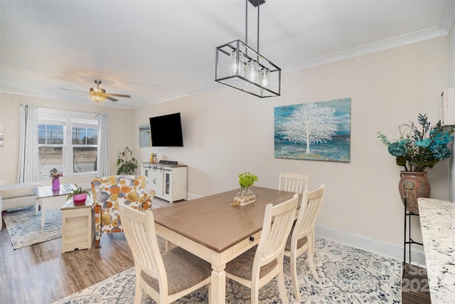 dining room featuring light hardwood / wood-style flooring, crown molding, and ceiling fan with notable chandelier