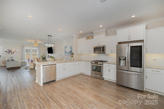 kitchen with stainless steel appliances, white cabinetry, decorative light fixtures, and kitchen peninsula