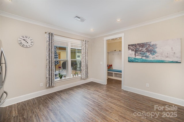 spare room featuring ornamental molding and dark hardwood / wood-style flooring