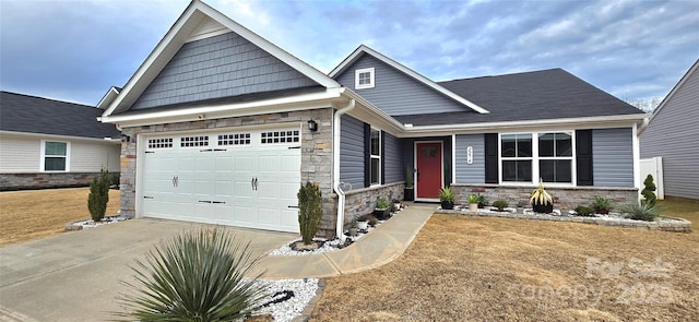 view of front of home with a front yard, stone siding, driveway, and an attached garage