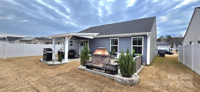 rear view of house featuring a yard and fence