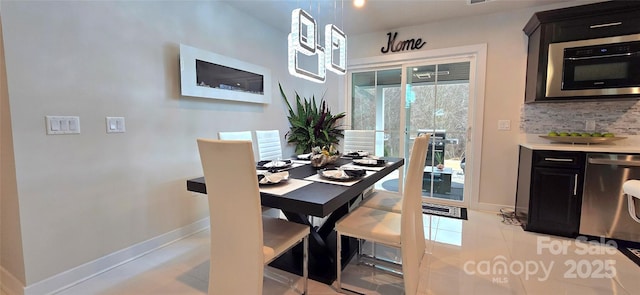 dining space with light tile patterned floors and baseboards