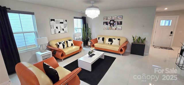 tiled living room featuring plenty of natural light and a notable chandelier