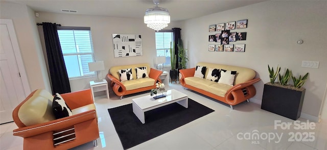 living room with tile patterned floors, a wealth of natural light, and an inviting chandelier