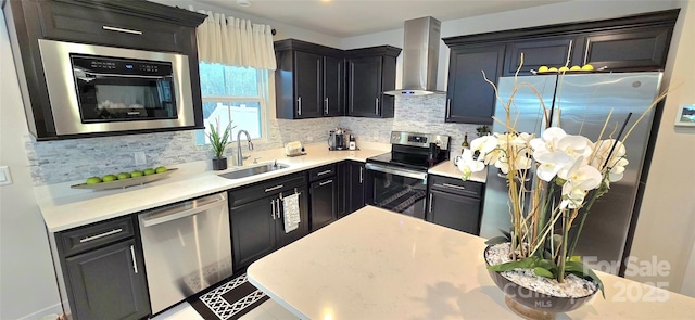 kitchen featuring wall chimney exhaust hood, stainless steel appliances, and light countertops