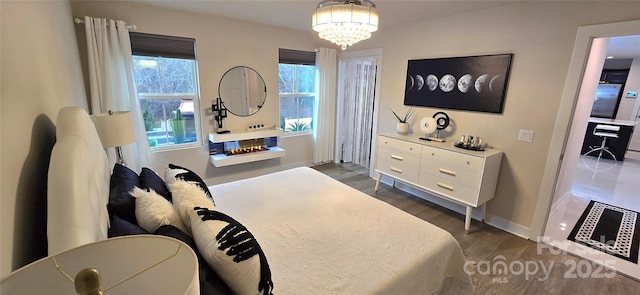 bedroom featuring dark hardwood / wood-style floors and an inviting chandelier