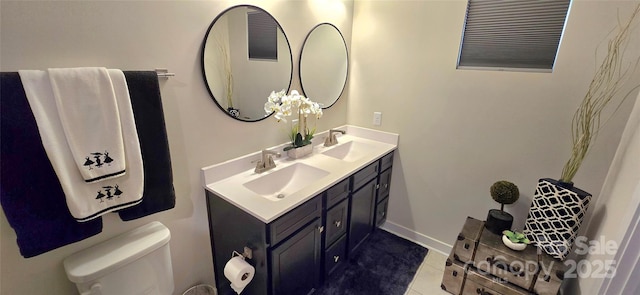 bathroom featuring double vanity, tile patterned flooring, a sink, and toilet