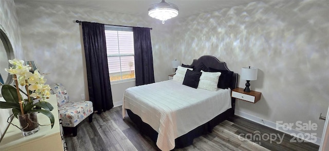 bedroom featuring baseboards and dark wood-type flooring