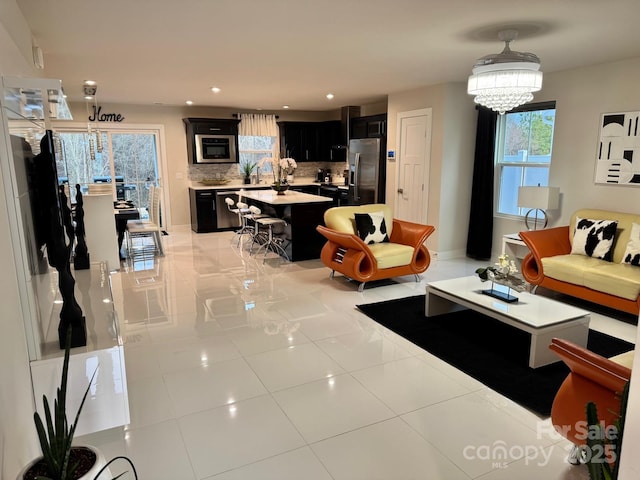 living room featuring a chandelier, light tile patterned flooring, and recessed lighting