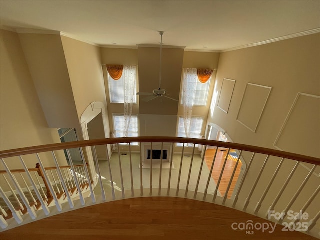 stairway with hardwood / wood-style floors, ceiling fan, and crown molding