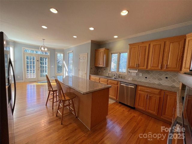 kitchen featuring sink, hanging light fixtures, a kitchen island, a kitchen bar, and stainless steel appliances