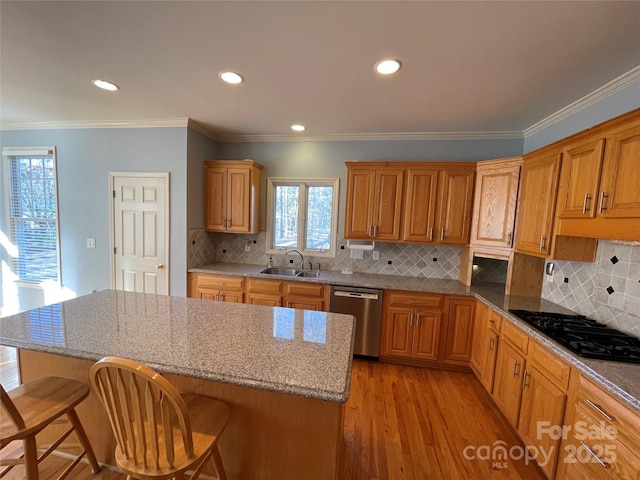 kitchen with decorative backsplash, a kitchen breakfast bar, sink, dishwasher, and a center island