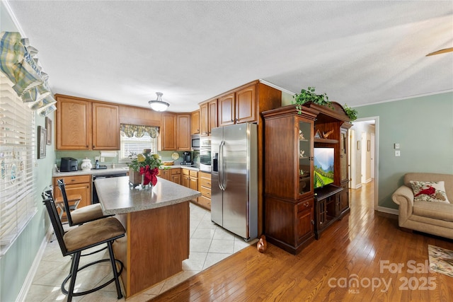 kitchen featuring a breakfast bar, a center island, light hardwood / wood-style floors, and stainless steel appliances