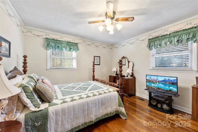 bedroom with ceiling fan, crown molding, wood-type flooring, and a textured ceiling