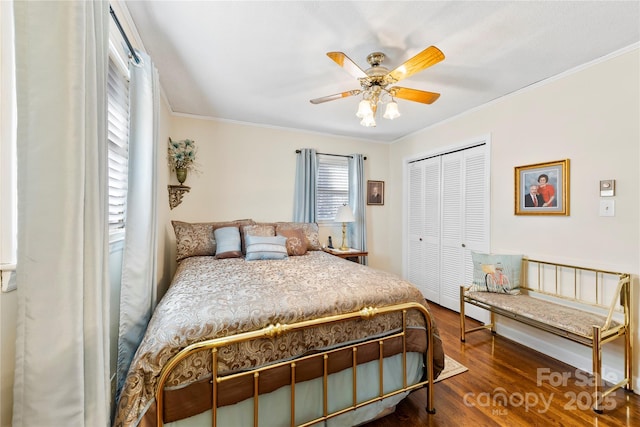 bedroom with hardwood / wood-style floors, a closet, ceiling fan, and crown molding