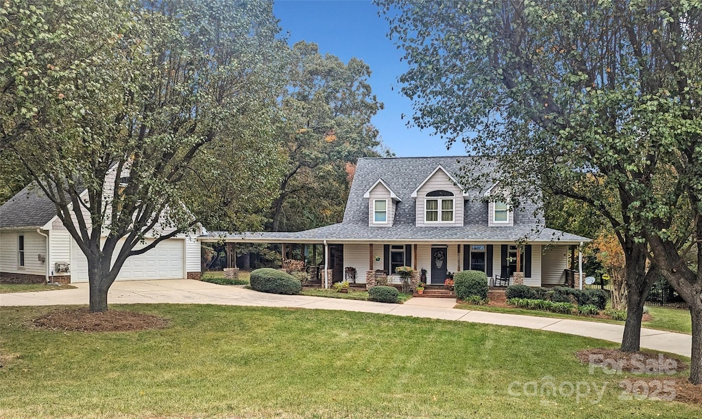 view of front facade featuring a porch, a garage, a front lawn, and an outdoor structure