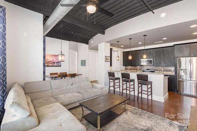 living room with beam ceiling, dark hardwood / wood-style floors, and ceiling fan