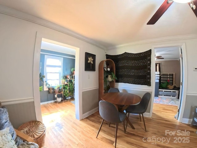 dining room with wood-type flooring and crown molding