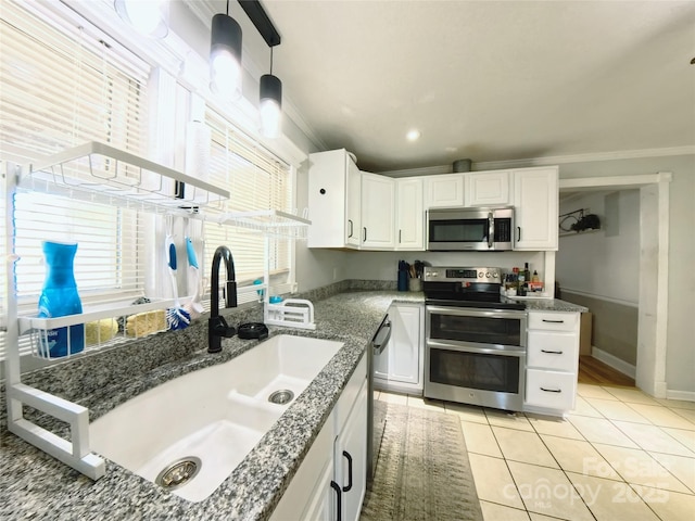 kitchen featuring pendant lighting, sink, light tile patterned floors, appliances with stainless steel finishes, and white cabinetry