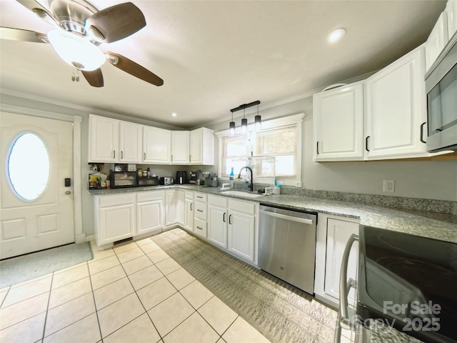 kitchen featuring sink, hanging light fixtures, light tile patterned floors, white cabinets, and appliances with stainless steel finishes