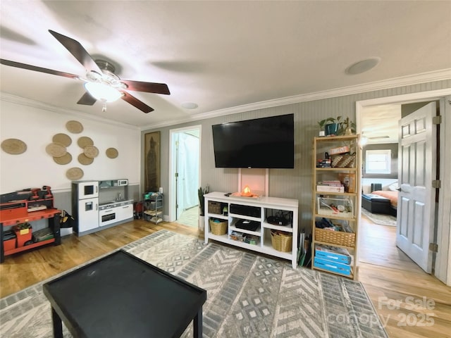 living room featuring crown molding, ceiling fan, and hardwood / wood-style flooring