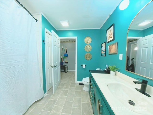 bathroom with vanity, toilet, and crown molding