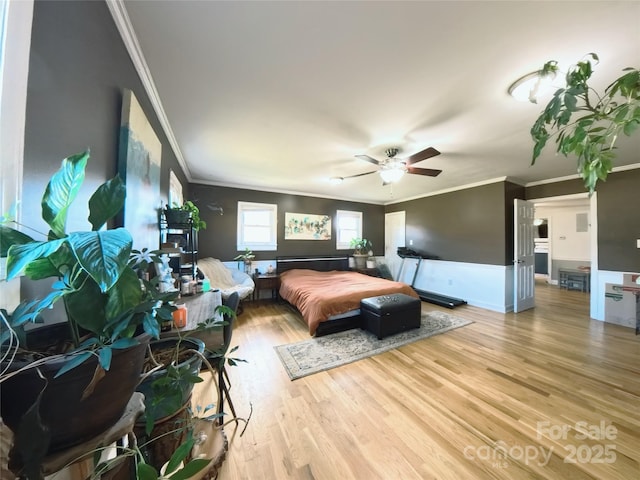 bedroom featuring light hardwood / wood-style floors, ceiling fan, and crown molding