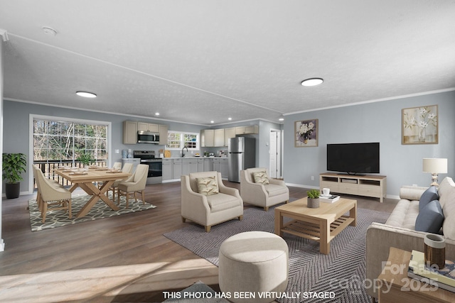 living room with wood-type flooring, ornamental molding, and sink