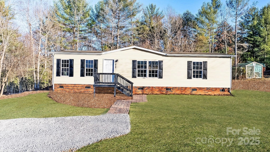 manufactured / mobile home featuring an outbuilding and a front yard