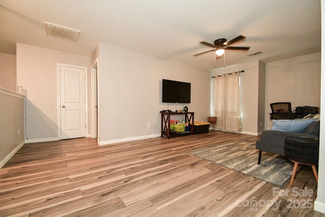 living room with light hardwood / wood-style floors and ceiling fan