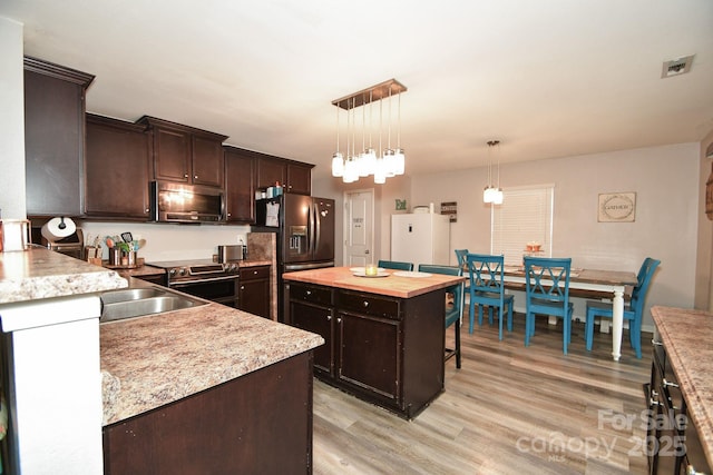 11677 Striker Ln, Midland, NC 28107 - kitchen with stainless steel appliances, dark brown cabinetry, light wood-type flooring, and butcher block counters