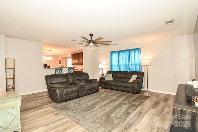 11677 Striker Ln, Midland, NC 28107 - living room featuring ceiling fan, wood finished floors, a chandelier, and baseboards