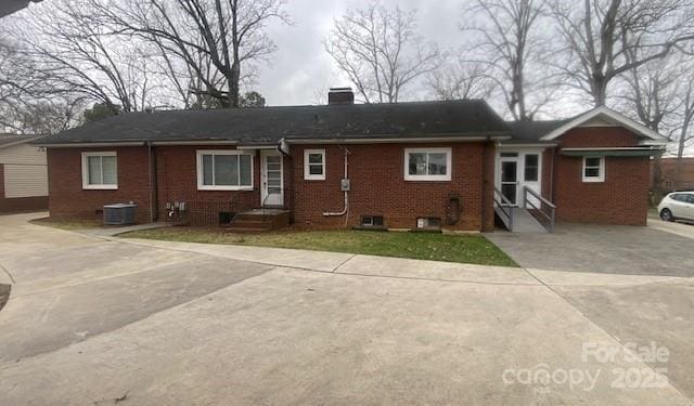 936 N 5th St, Albemarle, NC 28001 - back of property featuring entry steps, brick siding, a chimney, and driveway