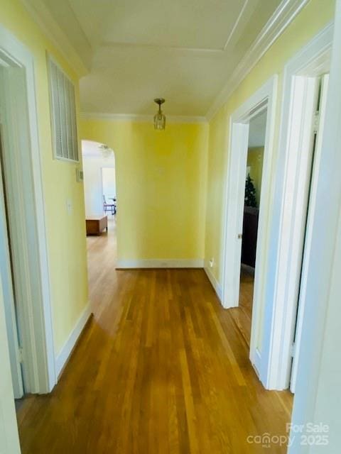 corridor featuring wood-type flooring and crown molding