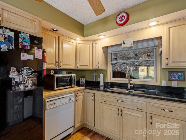 kitchen with dishwasher, black refrigerator, sink, a textured ceiling, and light hardwood / wood-style floors