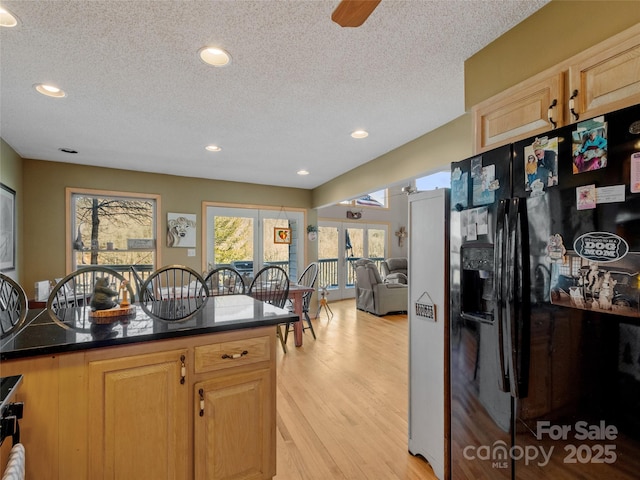 kitchen with a textured ceiling, light hardwood / wood-style flooring, black fridge, and ceiling fan